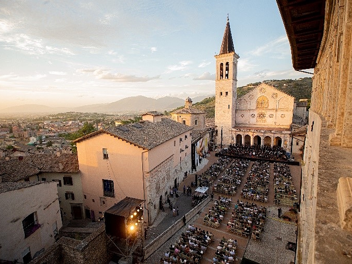 View from above of Piazza Duomo in Spoleto during the Festival dei Due Mondi, with the audience seated in front of the stage set up before the cathedral.