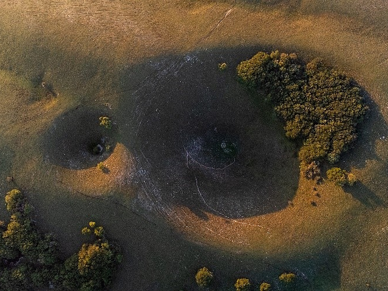 View from above of Monte Subasio’s mortari (rock hollows) illuminated by the warm light of the sunset.