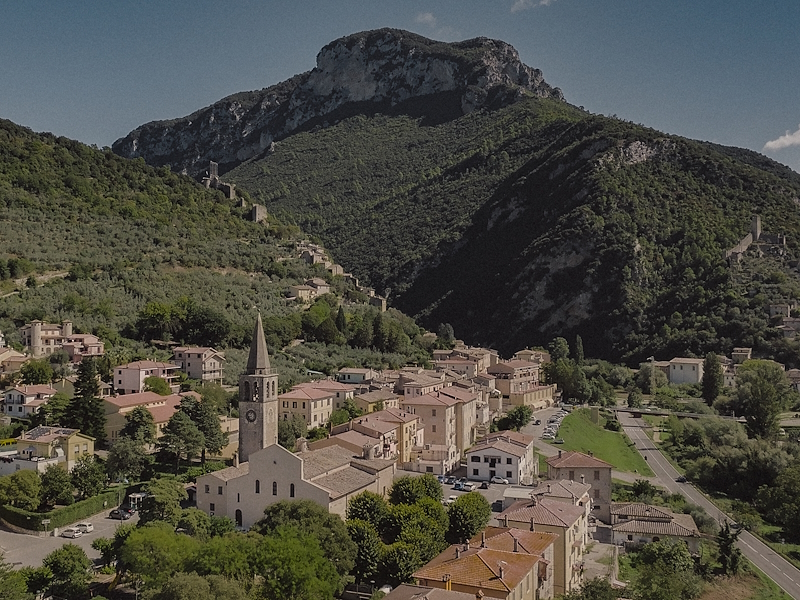 Panorama di Ferentillo con il centro abitato, il campanile della chiesa di Santo Stefano e le montagne della Valnerina sullo sfondo.