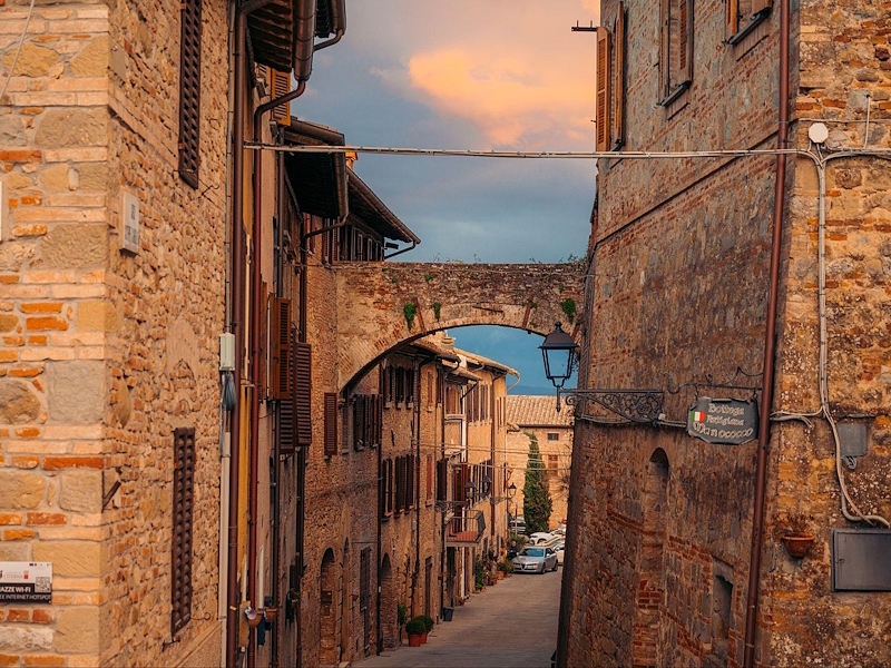 Medieval street in Citerna with stone houses and an arch connecting the buildings.