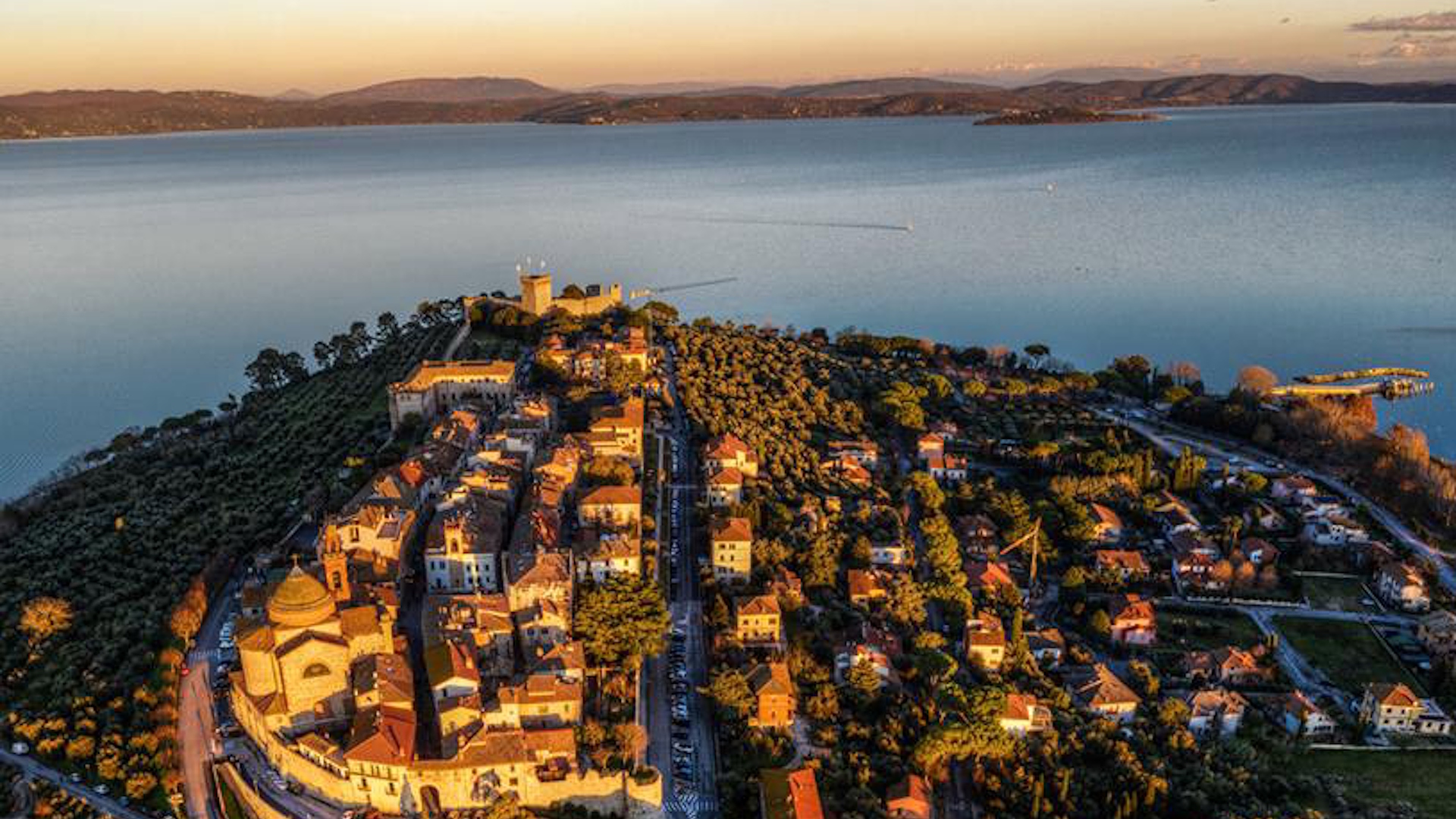 Aerial view of Castiglione del Lago at sunset, with the historic centre overlooking Lake Trasimeno.