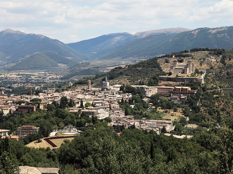 Panoramablick auf Spoleto mit der Altstadt, der Rocca Albornoziana und den umbrischen Bergen im Hintergrund.