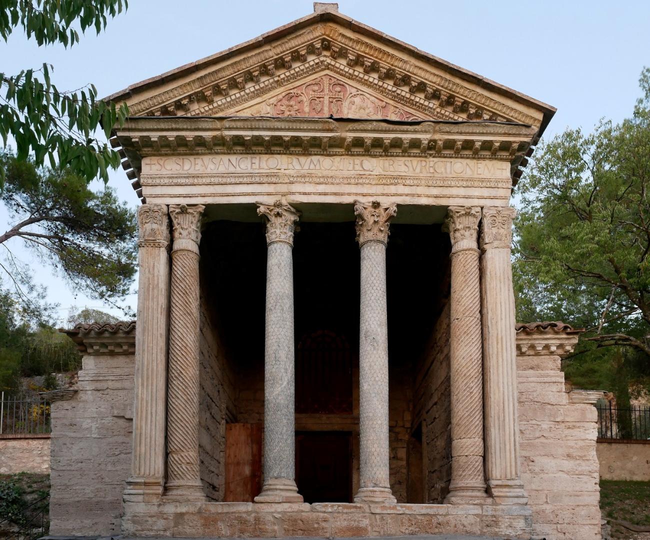 Close-up of the facade of the Tempietto del Clitunno, with fluted Corinthian columns and an architrave decorated with Latin inscriptions
