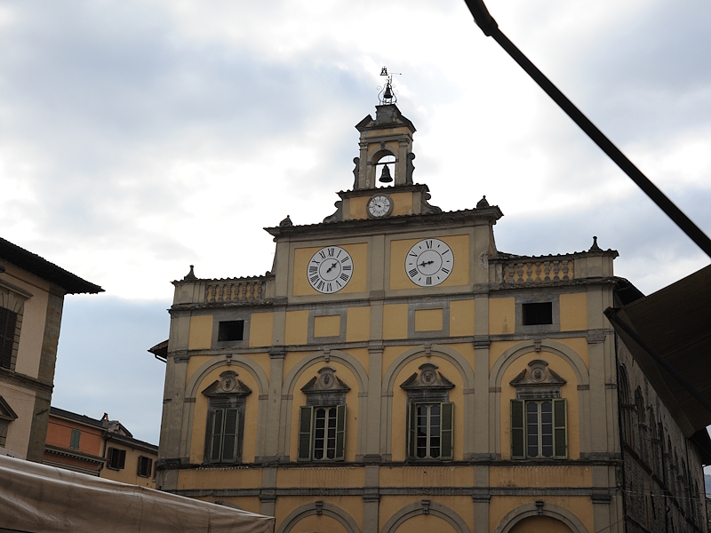 Facciata del Palazzo del Podestà a Città di Castello, con due grandi orologi e una torre campanaria.