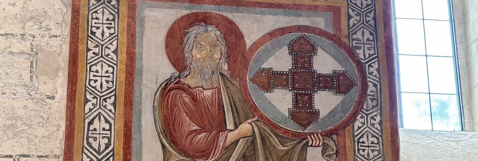 Medieval fresco inside the Church of San Bevignate in Perugia, depicting a sacred figure and Templar cross.