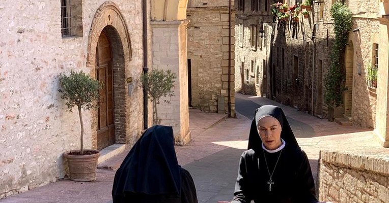 Elena Sofia Ricci, as Sister Angela, with another nun in a sunny medieval alley in Assisi.